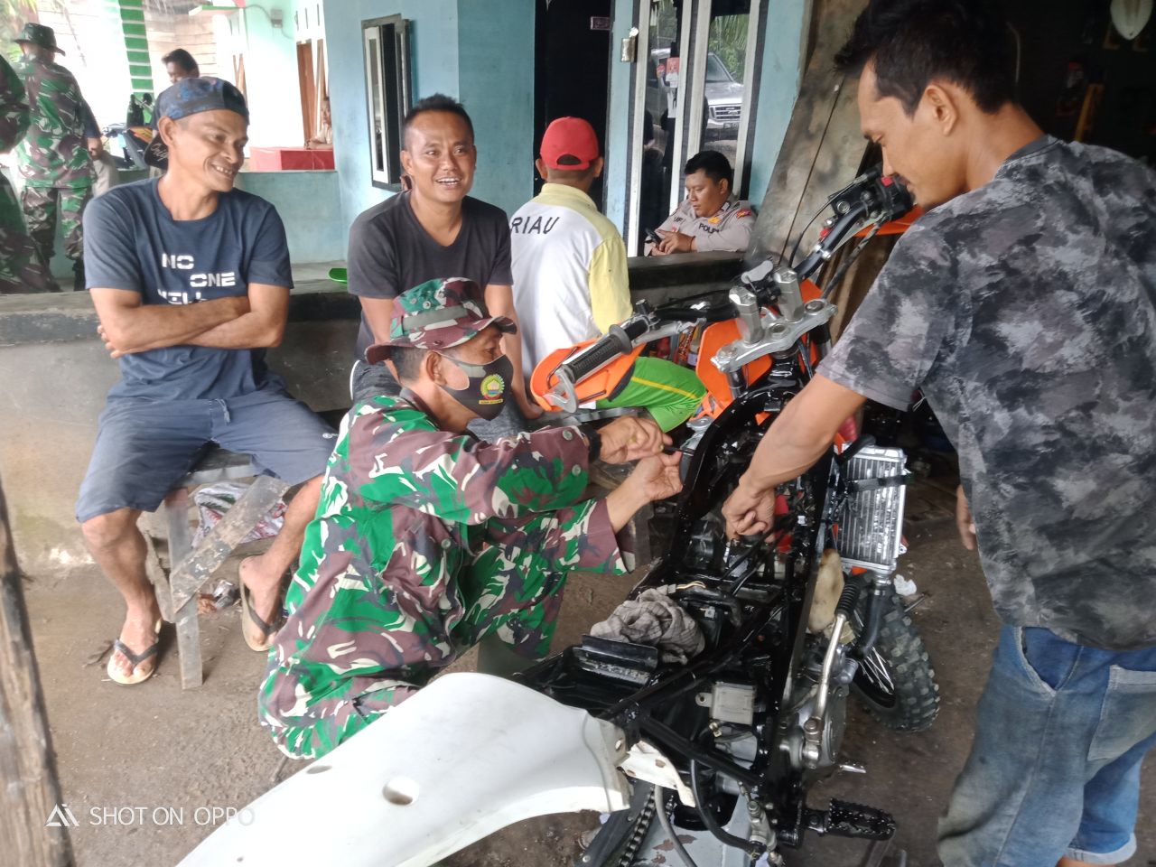 Jadi Montir Dadakan, Serma Andri mirzal Anggota Satgas TMMD Ke-110 Perbaiki Motor Warga