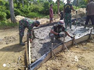 Satgas TMMD dan Masyarakat Mendatarkan material Cor